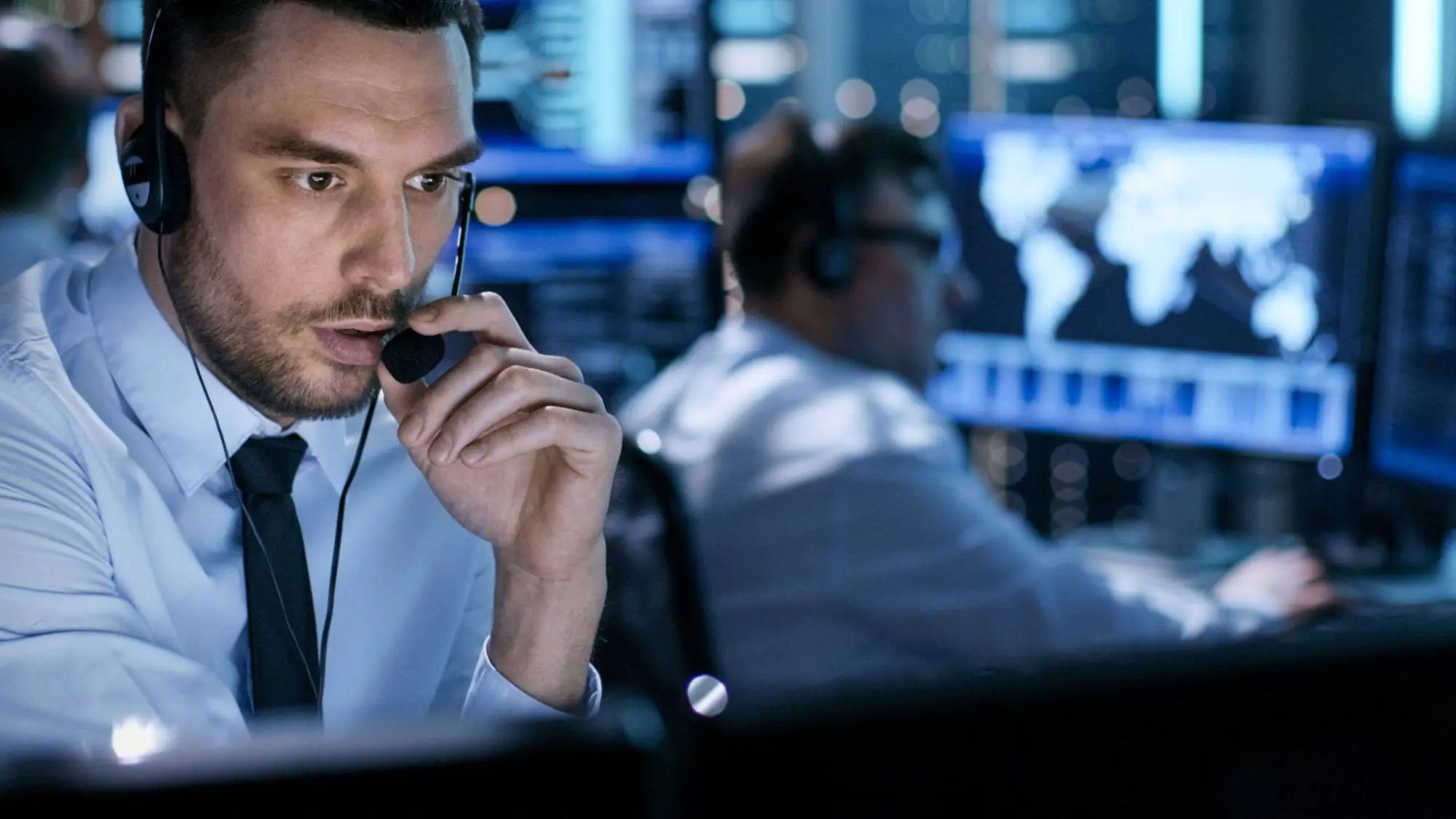 Operador com headset acompanhando telas em uma central de monitoramento de cargas